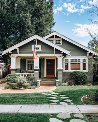Green Craftsman home exterior with white trim and columns
