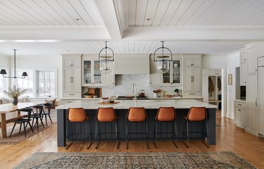 Blue and gray kitchen with cognac bar stools and white shiplap ceiling