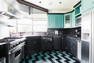 Teal green and black kitchen with chevron floor design