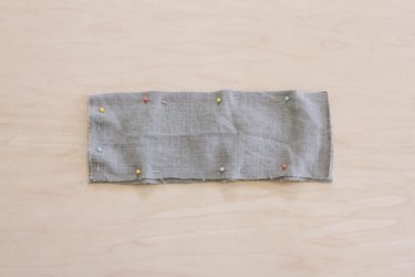 Two gray linen fabric pieces pinned together with right sides facing in