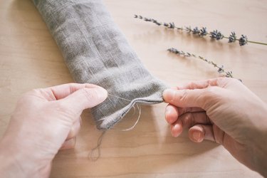 Sewing the opening of eye pillow closed with needle and thread