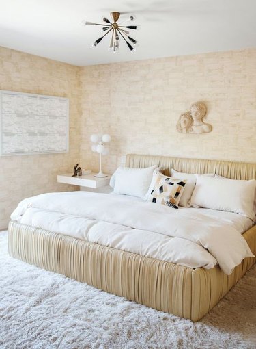 A luxury art deco bedroom with ruched bed frame and beige shades