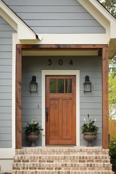 Blue gray Craftsman home exterior with warm wood front door and posts