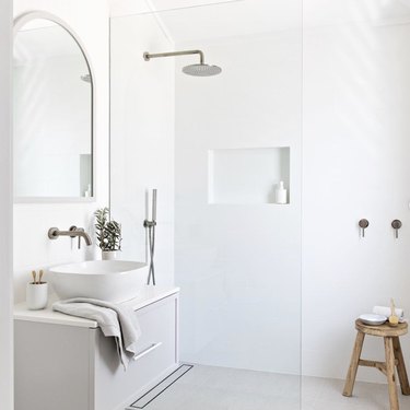 Minimalist bathrooms with shower and arched vanity mirror