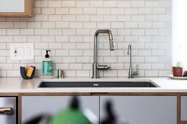 kitchen sink, white countertops, subway tile and garbage disposal