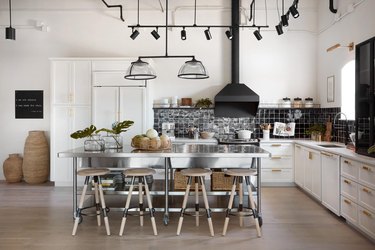 stainless steel kitchen island with wicker baskets and barstools