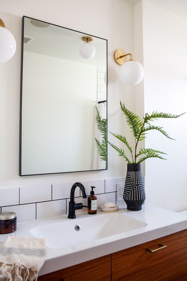 midcentury bathroom wall lighting idea in white bathroom with glass orb wall sconces