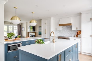 double blue kitchen island with brass accents and white countertop