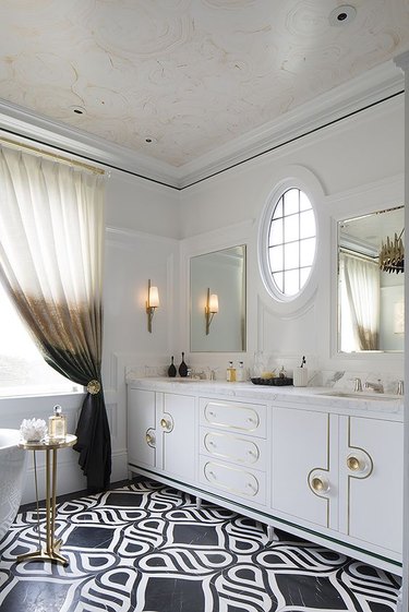 hollywood regency bathroom with black and white floor tile