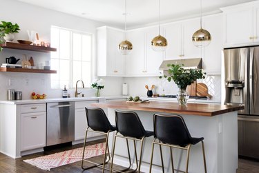 kitchen bar idea with modern kitchen with wooden island, pendant lighting and gold detail bar stools