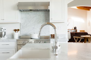 white kitchen island countertop and chrom single-handle kitchen faucet