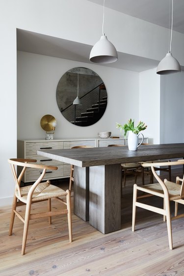 dining table with pendant lights and wishbone chairs