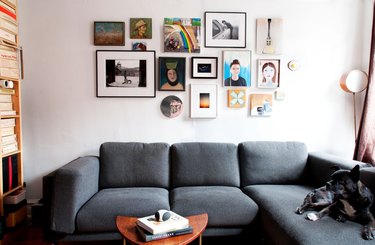 couch with picture frame collage wall above