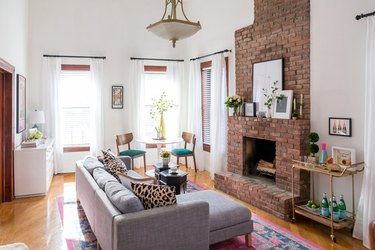 living room with brick fireplace and bar cart