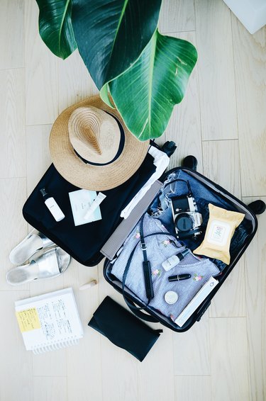 black luggage with clothes and camera