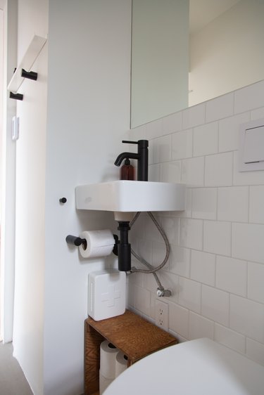 A recessed mirror and concrete floors in the bathroom.