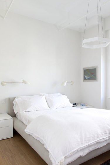 minimal bedroom with sconces and pendant light