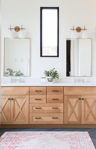 bathroom mirror idea with wooden vanity with thin brass framed mirrors and vintage light fittings