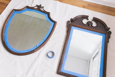 Two wooden thrift store mirrors with painter's tape around edges of frame