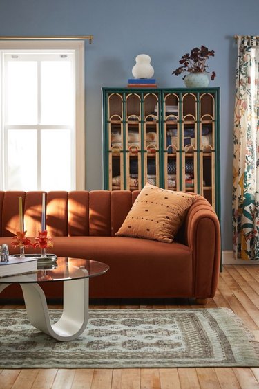 orange sofa in periwinkle living room