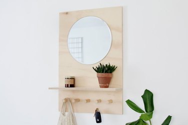 Wood and mirror wall organizer with pegs and shelf
