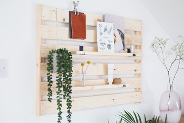 ikea hack of IKEA Hejne shelf turned into wood shelving unit with plants and cards on it