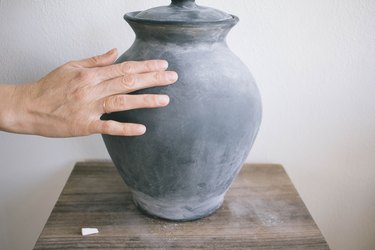 Rubbing chalk with fingertips on chalkboard-painted lamp