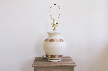 Thrift store lamp with pink and yellow flowers on small table