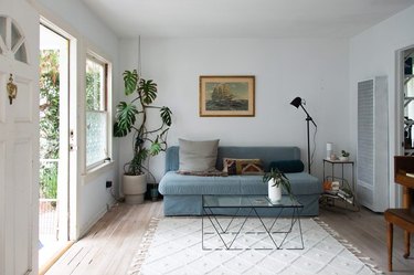 living room space with open door, blue couch, and black coffee table