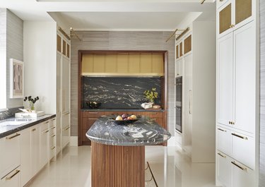 Art deco kitchen with marble backsplash and island and custom white cabinets