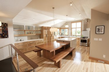 wooden kitchen island table in kitchen vaulted ceilings and polished wood floors