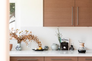 view of light stone kitchen countertop with coffee in carafe  and kitchen cabinets