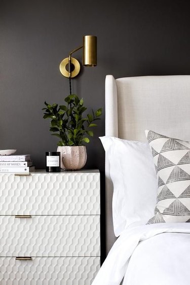 black guest bedroom idea with white headboard and white nightstand
