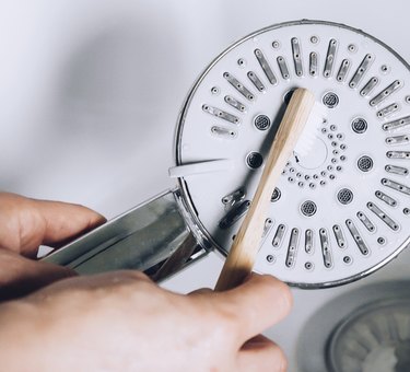 cleaning showerhead with toothbrush