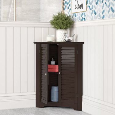 Multipurpose Corner Bathroom Cabinet with Shutter Doors and potted plant on top