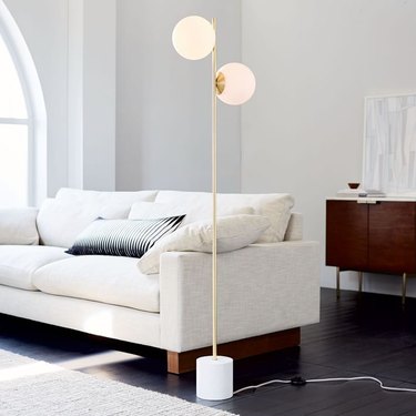 living room space with white couch and floor lamp