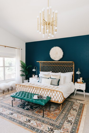 blue bohemian bedroom with rattan bed and midcentury light fixtture