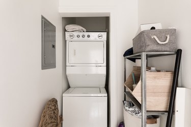 laundry room featuring standing washer-dryer with laundry baskets and breaker box