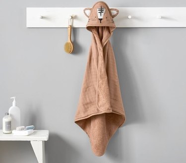 hooded kids towel hanging on white hook