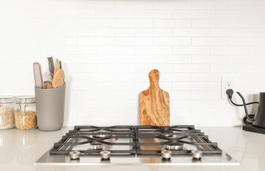 cooktop on white countertop and white tile backsplash