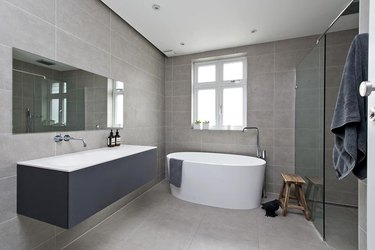 minimalist bathroom vanity with large white bathtub.