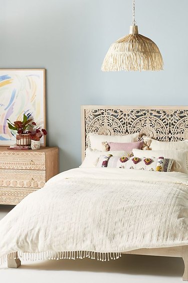 light blue bohemian bedroom idea with tan furniture and hanging pendant