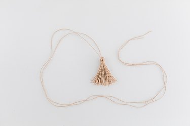 Close the tassel around the long piece of twine, and knot it to finish it off.