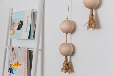 Hang the finished threaded beads on the wall using a hammer and picture hanging nails.