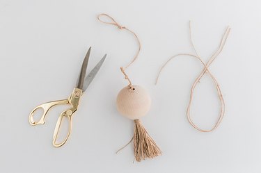 Tie a few decorative knots along the length of the twine, then knot a loop into the end.