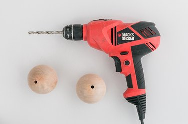 Drill holes through the wood balls.