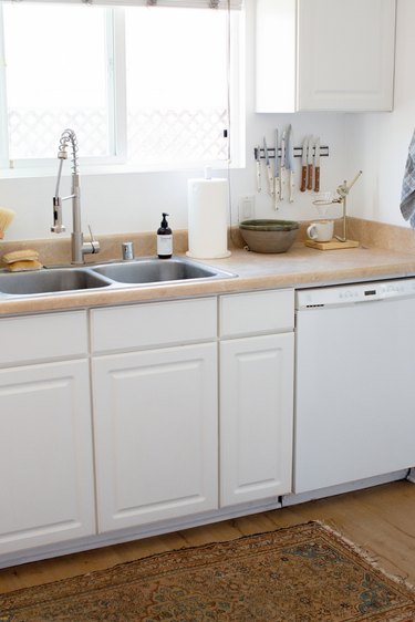 white kitchen cabinetry, wood countertops and pull down kitchen sink faucet
