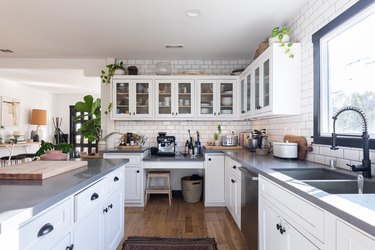 Kitchen with white cabinetry, gray countertops, and pull-down kitchen sink faucet.