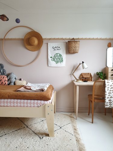 pink and brown minimalist girl bedroom with hula hoop and peg rail