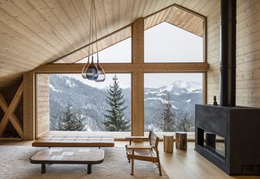 pine-covered chalet living room with wood burning stove and minimal decor